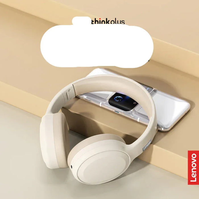 White headphones with a smartphone on a beige surface, featuring Lenovo branding.