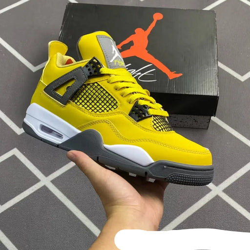 Yellow sneaker held in hand with Jordan brand box in the background