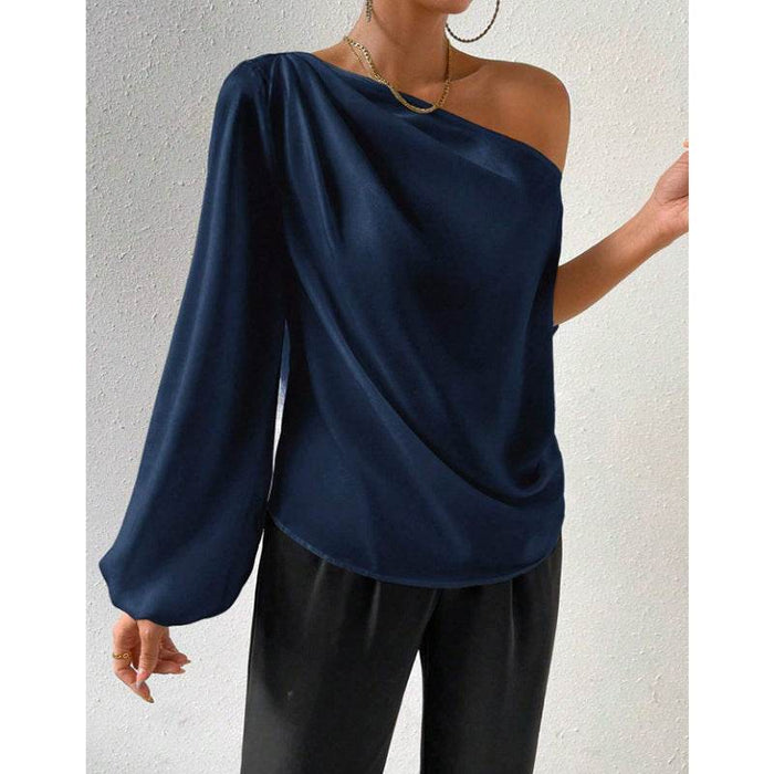 Navy blue one-shoulder top worn by a person on a light gray background