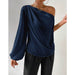 Navy blue one-shoulder top worn by a person on a light gray background
