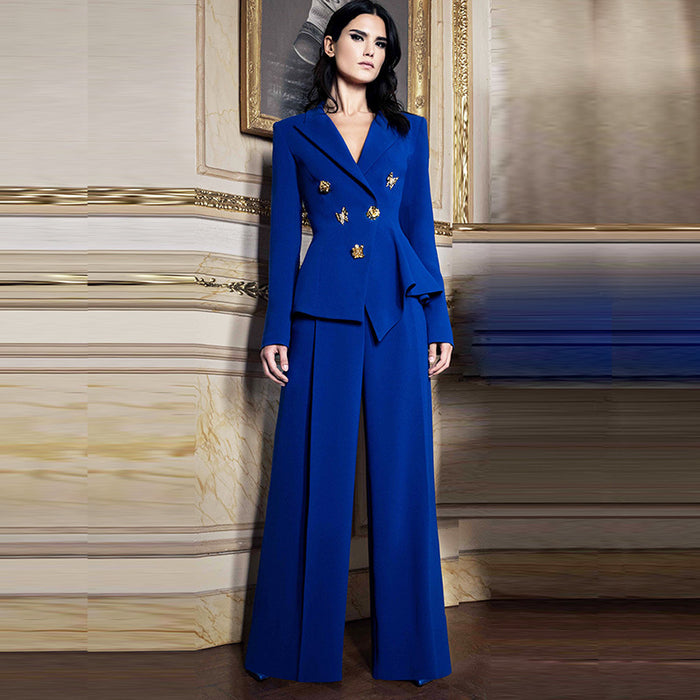 Woman wearing a blue suit with gold accents in an elegant room.