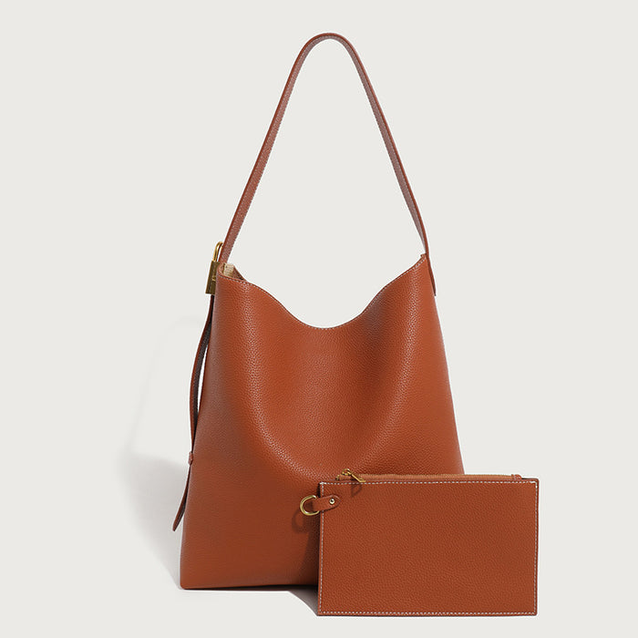Brown leather handbag with matching pouch on a light gray background