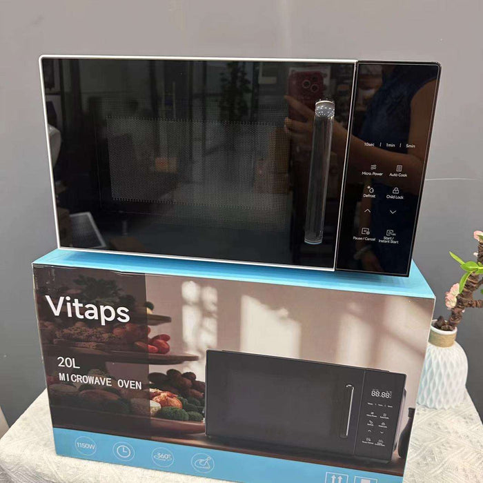 Black microwave oven on top of its packaging box with 'Vitaps' branding.