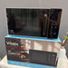 Black microwave oven on top of its packaging box with 'Vitaps' branding.
