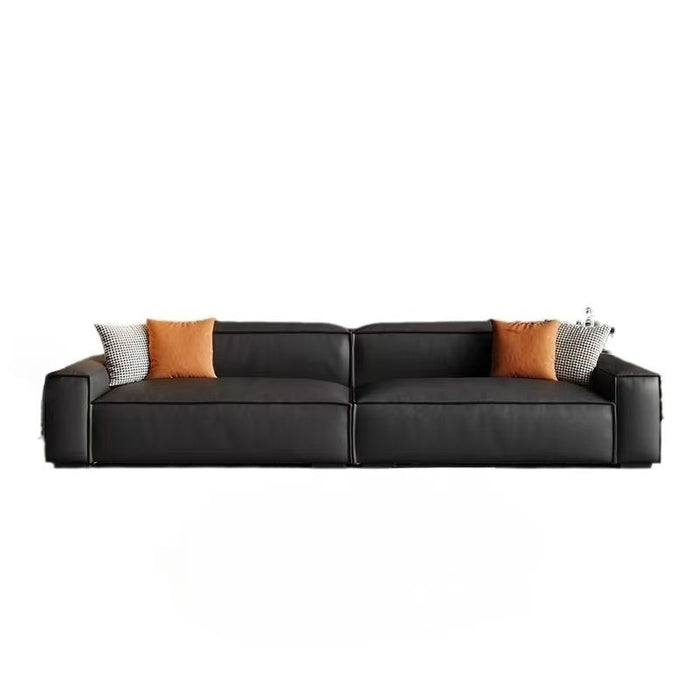 Black leather sectional sofa with colorful cushions on a white background