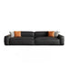 Black leather sectional sofa with colorful cushions on a white background