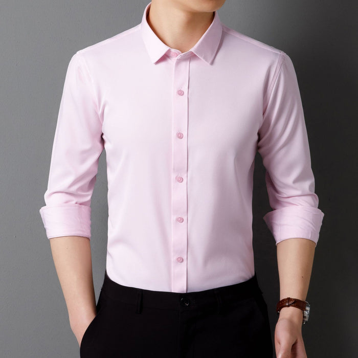 Light pink dress shirt with rolled-up sleeves worn by a person on a gray background