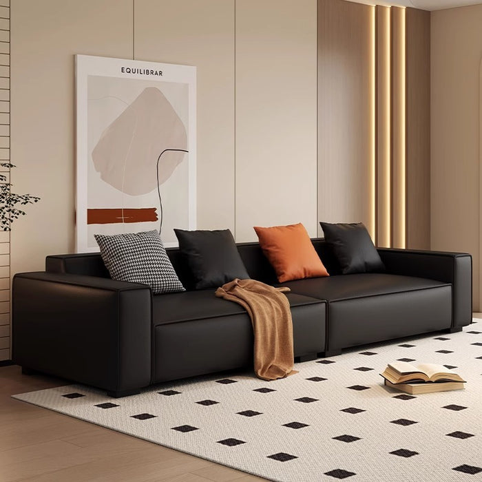 Modern black sofa with colorful cushions in a stylish living room.