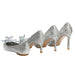 Silver high-heeled shoes with crystal embellishments on a white background