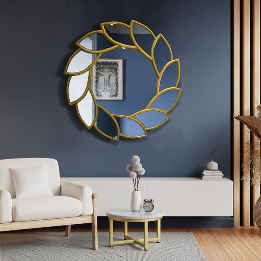Decorative wall mirror with gold leaf design in a living room setting.