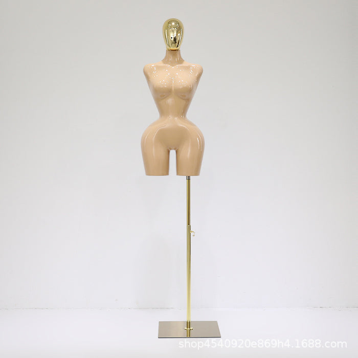 Mannequin torso on a stand with a gold head against a white background