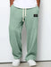 Green textured sweatpants with a white label on a plain background