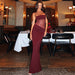 Woman in a burgundy dress standing in a restaurant setting