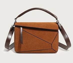Brown handbag with a brown strap on a light gray background