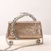 Gold glitter handbag with chain handle on a white background
