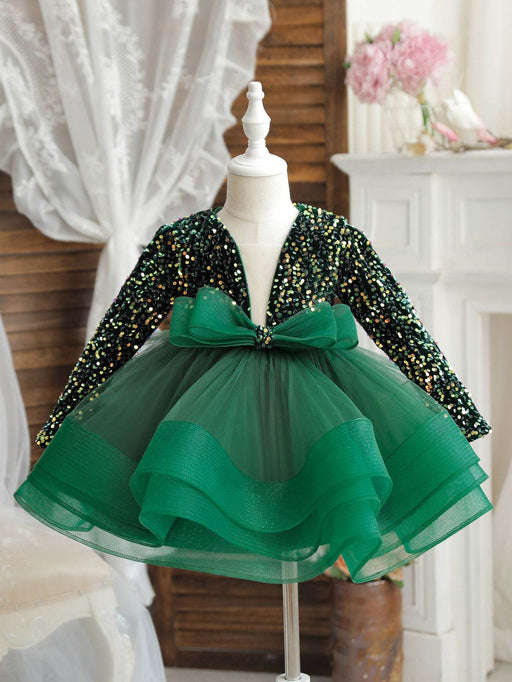 Green sequin dress with a large bow on a mannequin against a neutral background