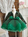 Green sequin dress with a large bow on a mannequin against a neutral background