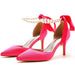 Pink high-heeled shoes with red ribbons and pearl necklace on a white background