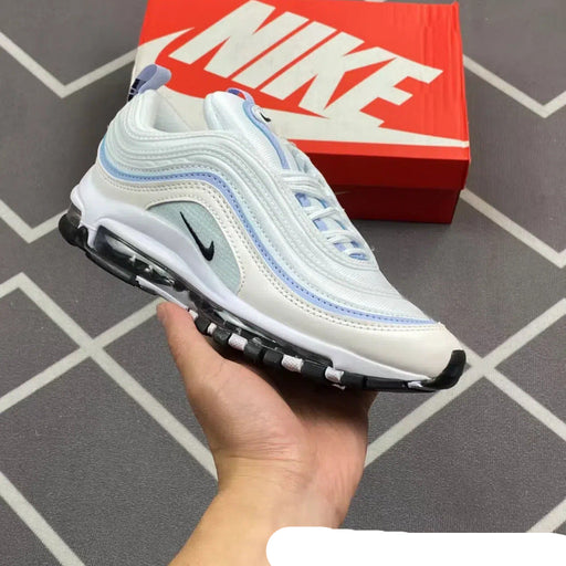 White Nike sneaker held in hand with red Nike box in the background