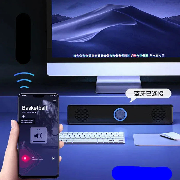 Smartphone displaying a music app with a computer and Bluetooth speaker on a desk.