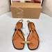 Pair of tan sandals with gold accents on a white surface, next to a Zara box.