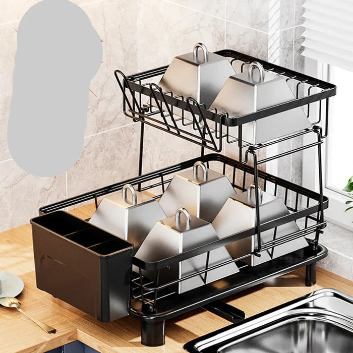 Black dish rack with silver dishes on a kitchen counter