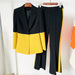 Black and yellow suit jacket with matching pants on hangers against a white background