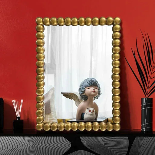 Decorative mirror with gold frame on a red wall