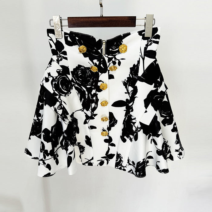 Black and white floral blouse with gold buttons on a hanger against a white background