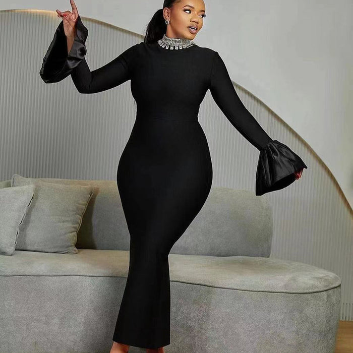 A woman wearing a black long-sleeve dress with a round neckline and a high waist, featuring a solid color with a zipper at the placket.
