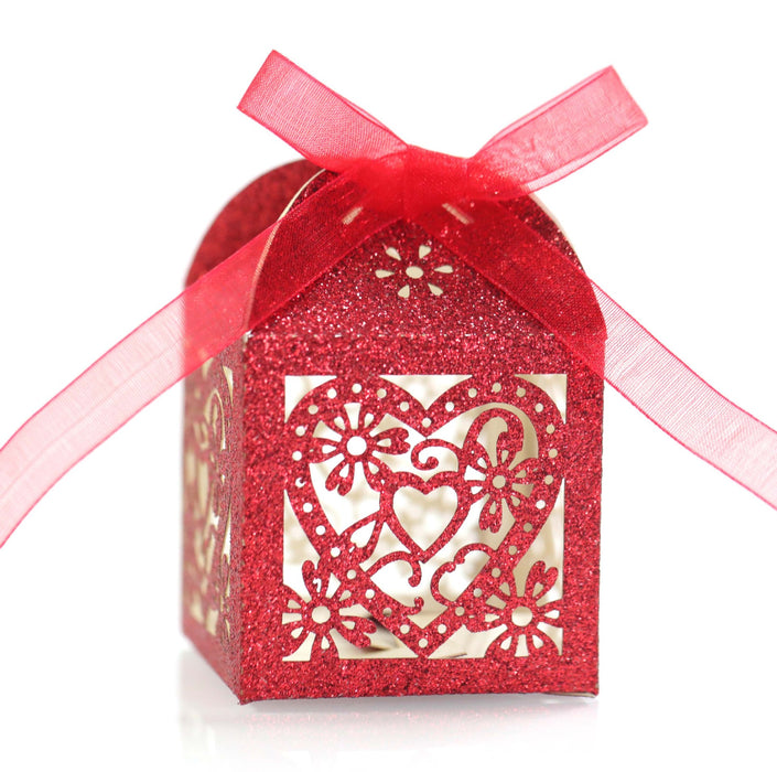 Red decorative box with floral cutout and pink ribbon on a white background