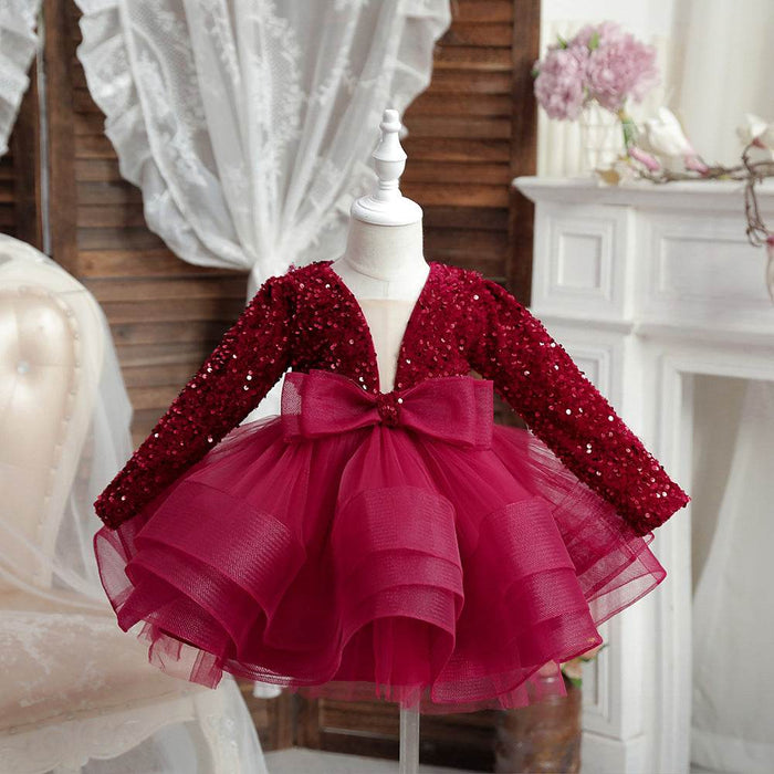 Red sequin dress with a bow on a mannequin against a decorative background