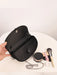 Black handbag with makeup items on a white surface