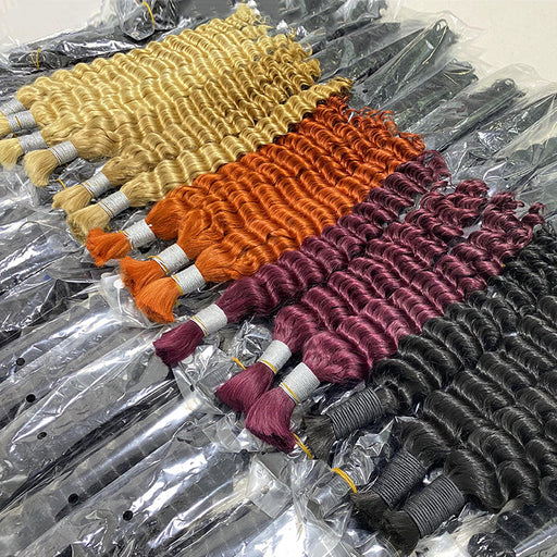 Four bundles of hair extensions in different colors on a clear plastic surface.
