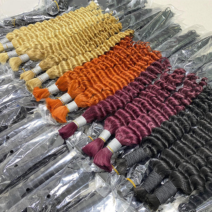 Four bundles of hair extensions in different colors on a clear plastic surface.