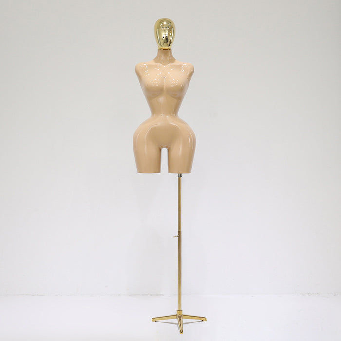 Mannequin torso on a stand with a gold head against a white background