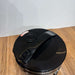 Black trash can with a lid on a wooden surface
