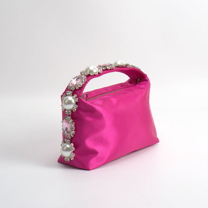 Pink handbag with decorative handle on a white background