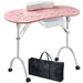 Pink nail art table with white wheels and a black carrying bag on a white background
