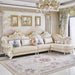 Luxurious living room with a cream-colored sofa, decorative pillows, and a chandelier.
