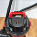 Close-up of a red and black vacuum cleaner on a wooden floor.
