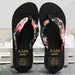Black flip-flops with floral straps and 'AMH' branding on a light background