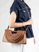 Person holding a brown handbag with a white background
