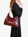 Person holding a red handbag against a white background