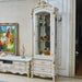 Decorative white cabinet with gold accents in a room with a painting and furniture.