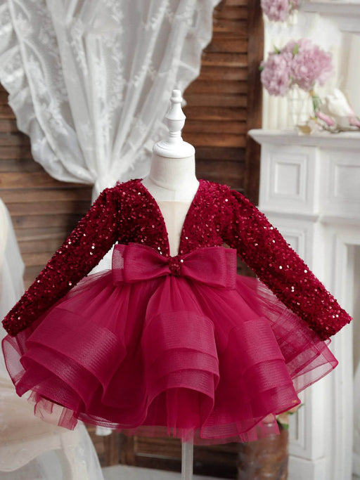 Red sequin dress with a bow on a mannequin against a decorative background