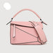 Pink handbag with a strap on a light gray background