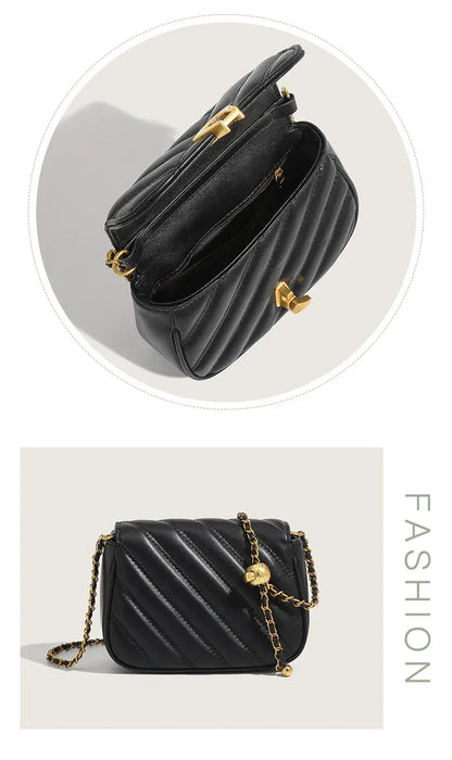 Black handbag with gold accents on a light gray background