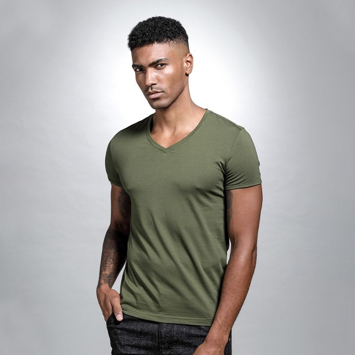 Man wearing a green t-shirt against a gray background