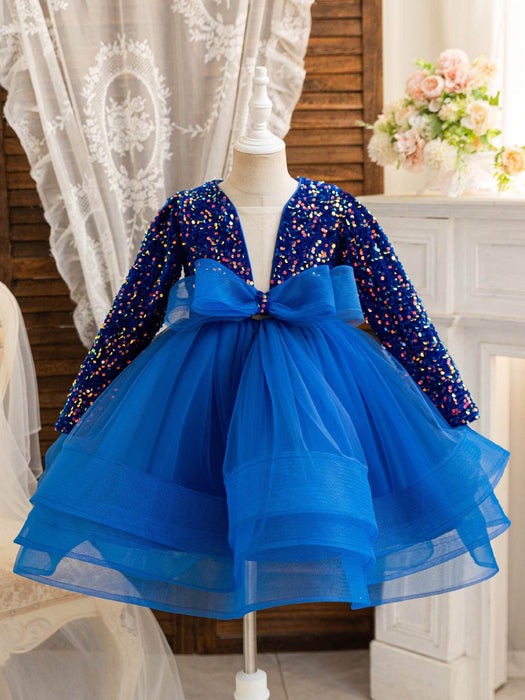 Blue dress with sequined long-sleeve top on a mannequin against a decorative background.